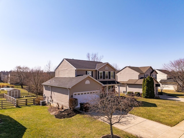 traditional home featuring a front lawn, fence, a storage shed, an outbuilding, and driveway