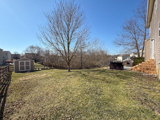 view of yard with an outbuilding, a storage unit, and fence