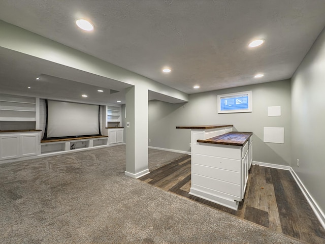 interior space featuring recessed lighting, baseboards, dark wood-type flooring, and a textured ceiling