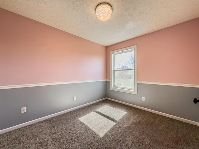 carpeted empty room with baseboards and a textured ceiling