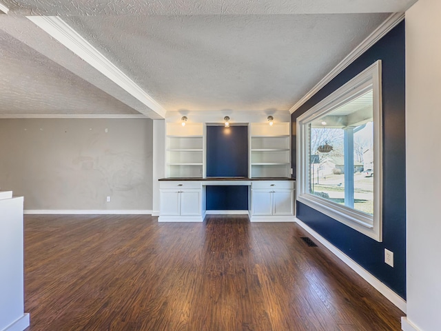 unfurnished living room featuring baseboards, visible vents, dark wood-style flooring, and built in study area