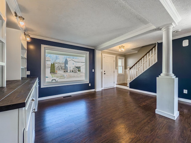 foyer with stairway, visible vents, dark wood finished floors, decorative columns, and crown molding