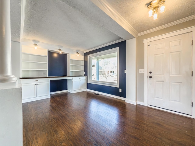 foyer featuring visible vents, ornamental molding, a textured ceiling, wood finished floors, and baseboards