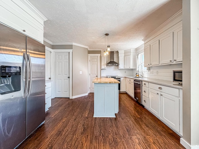 kitchen featuring a sink, a kitchen island, dark wood-style floors, stainless steel appliances, and wall chimney range hood