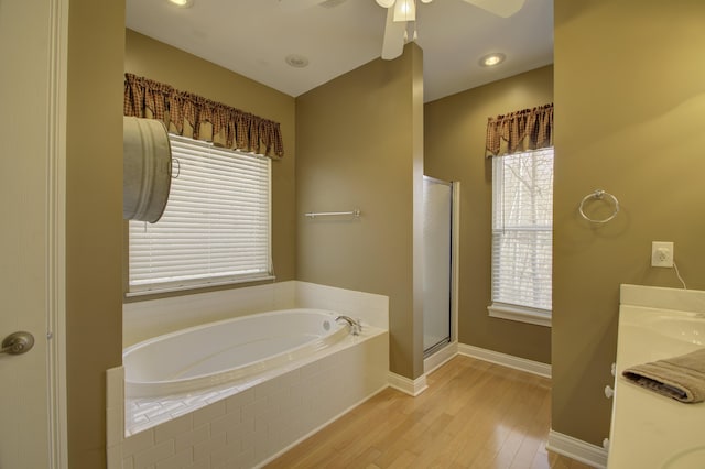 bathroom with ceiling fan, shower with separate bathtub, and hardwood / wood-style flooring