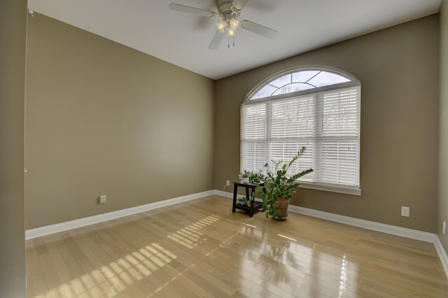 empty room with ceiling fan and light hardwood / wood-style floors