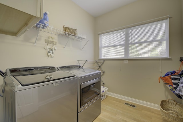 laundry room with light hardwood / wood-style floors and independent washer and dryer