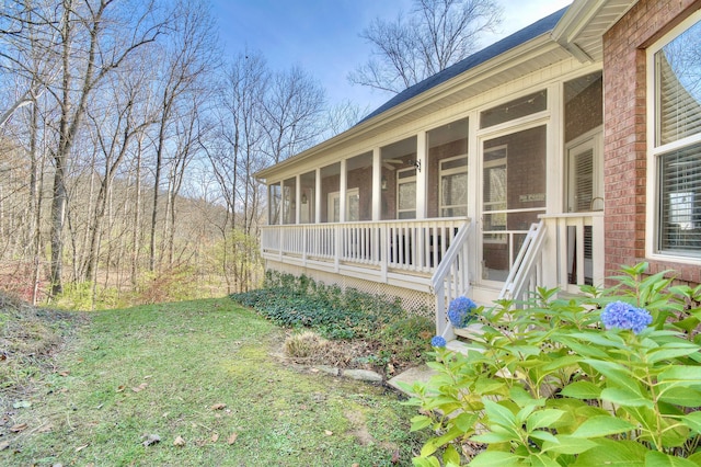 view of side of property featuring a lawn and a sunroom