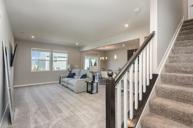 carpeted living room with a chandelier