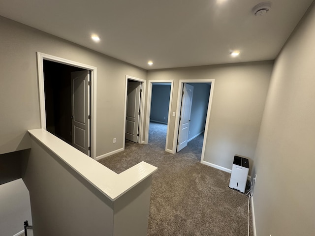 hall featuring dark colored carpet