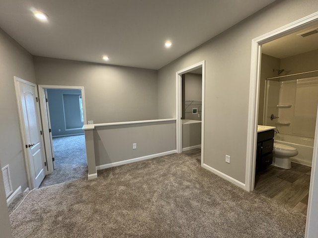 unfurnished bedroom with a spacious closet, connected bathroom, a closet, and carpet flooring