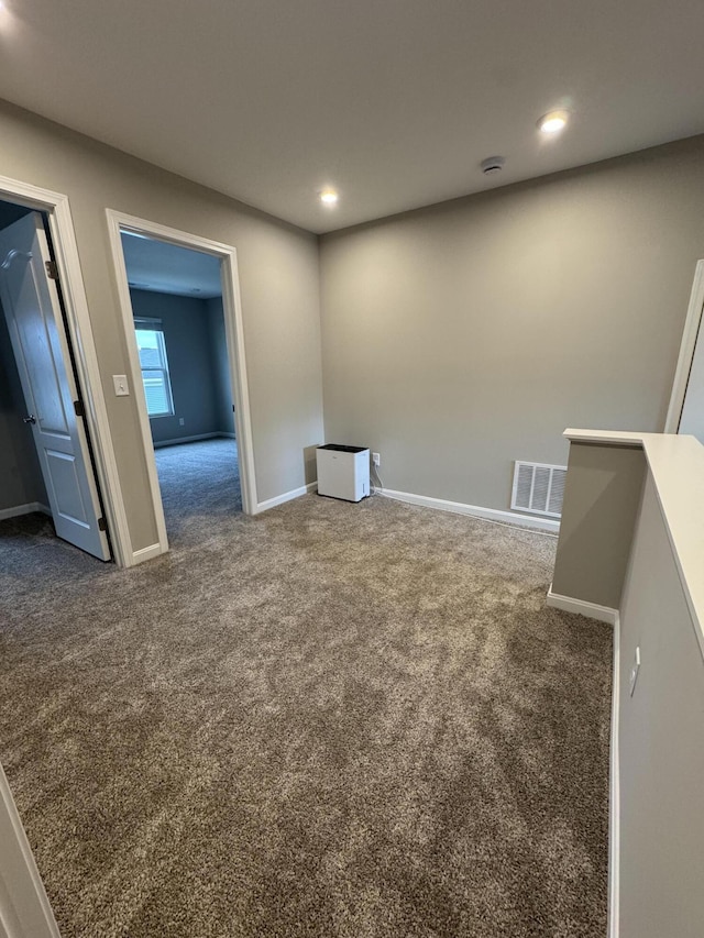 unfurnished room featuring dark carpet