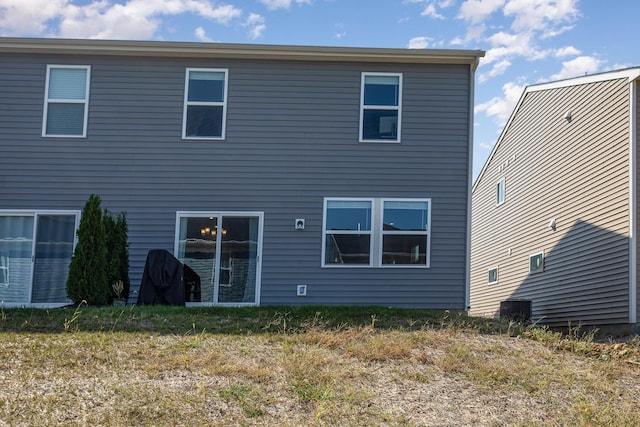 rear view of property featuring a lawn