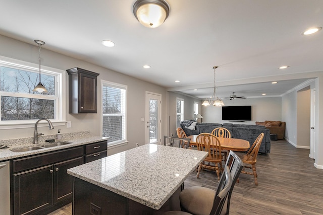 kitchen with ceiling fan, a kitchen island, wood-type flooring, sink, and dark brown cabinetry