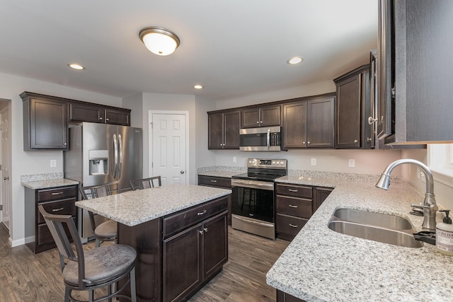 kitchen featuring dark hardwood / wood-style flooring, sink, stainless steel appliances, and a center island