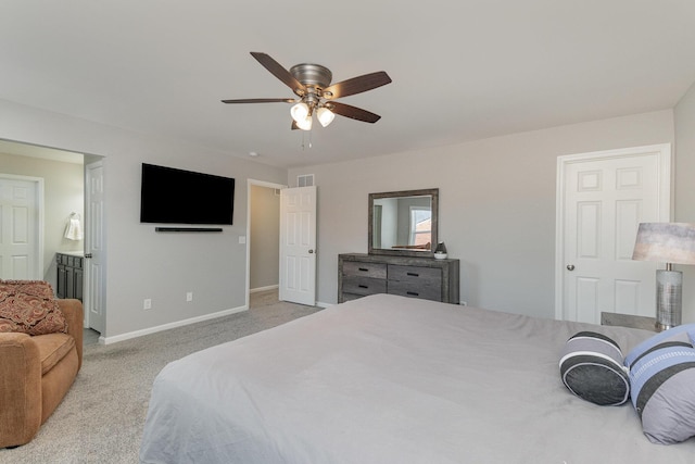 carpeted bedroom with ceiling fan and ensuite bath