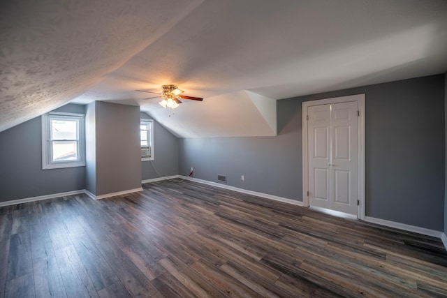 additional living space with lofted ceiling, dark hardwood / wood-style floors, and ceiling fan