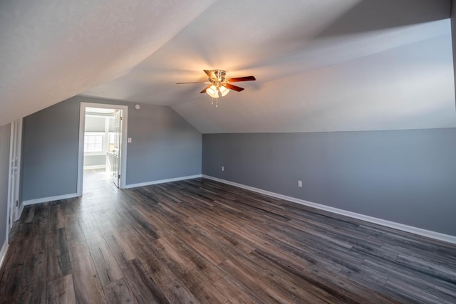 additional living space with lofted ceiling, dark wood-type flooring, and ceiling fan