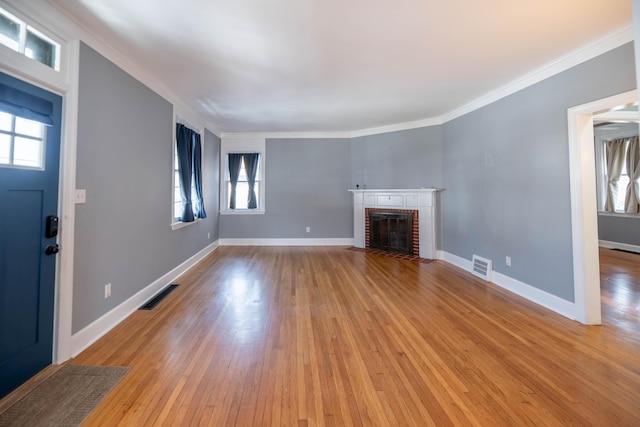 unfurnished living room with crown molding, a fireplace, and light hardwood / wood-style flooring