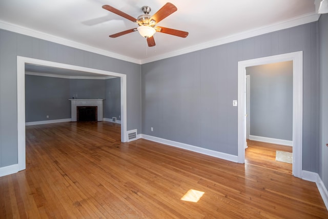 unfurnished living room with a brick fireplace, crown molding, light hardwood / wood-style floors, and ceiling fan