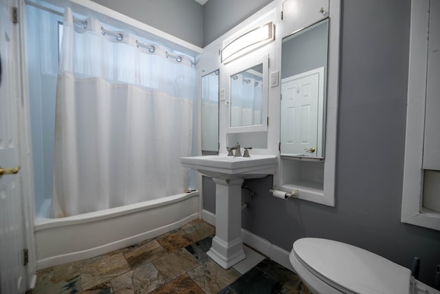 bathroom featuring shower / tub combo with curtain and toilet