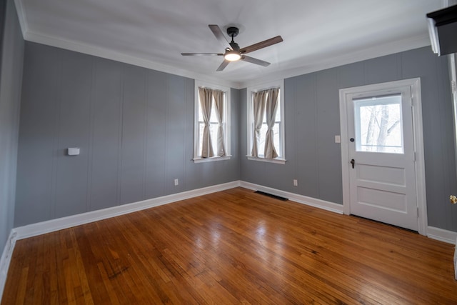 entryway with ceiling fan, ornamental molding, and wood-type flooring