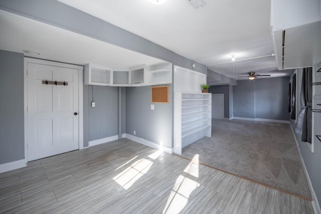 basement with light colored carpet and ceiling fan