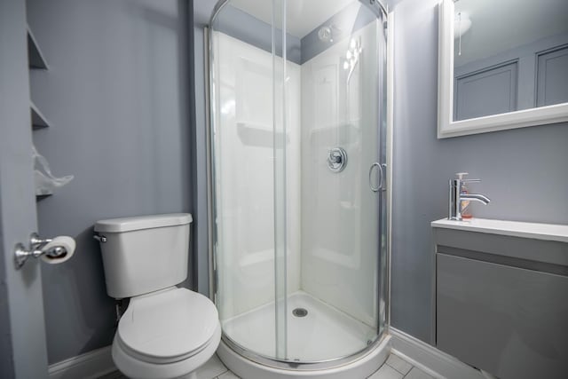 bathroom with vanity, tile patterned flooring, toilet, and walk in shower