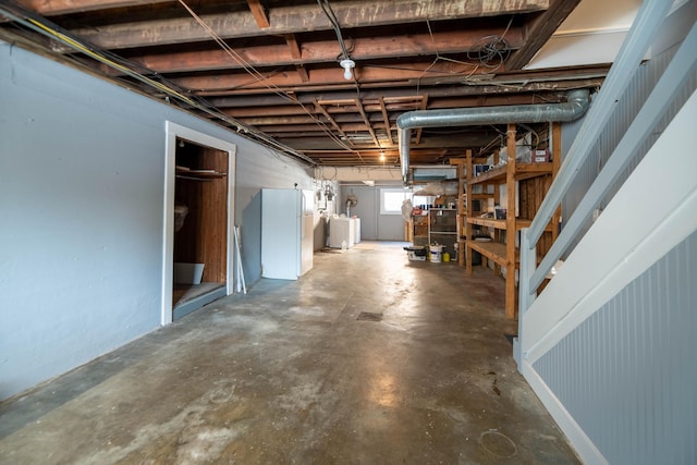 basement featuring white refrigerator and independent washer and dryer