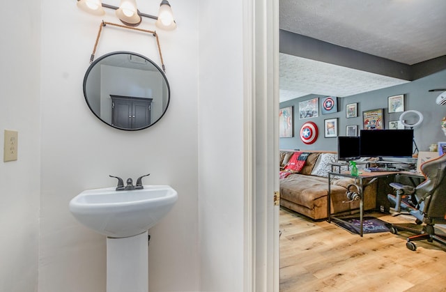 bathroom featuring wood-type flooring and a textured ceiling