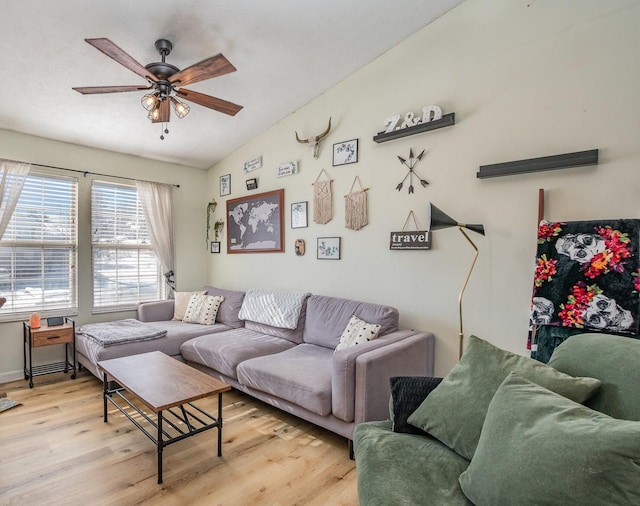 living room with lofted ceiling, ceiling fan, and light wood-type flooring