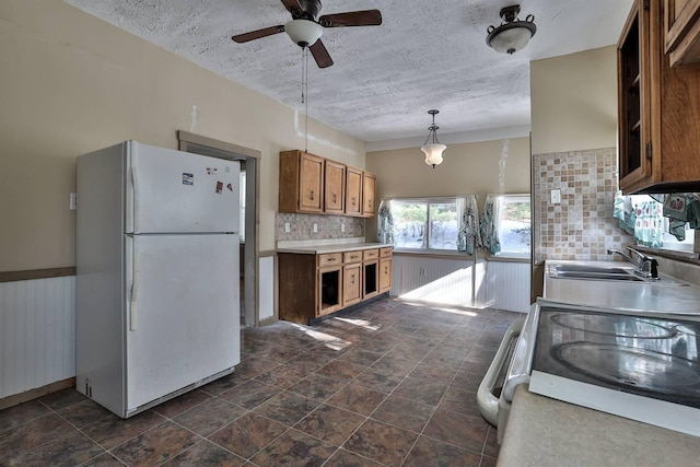 kitchen featuring white fridge, ceiling fan, decorative backsplash, stainless steel electric stove, and sink