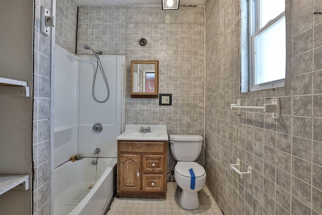 full bathroom featuring toilet, vanity, tile walls, and shower / washtub combination