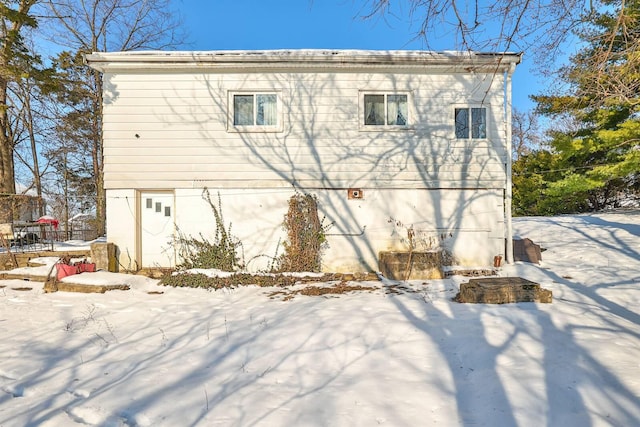 view of snow covered back of property