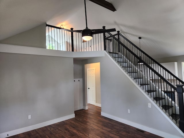 stairs with high vaulted ceiling, hardwood / wood-style floors, and beamed ceiling