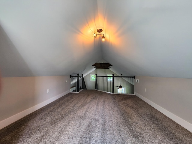 additional living space with vaulted ceiling and carpet flooring