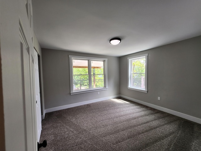 unfurnished bedroom with dark carpet