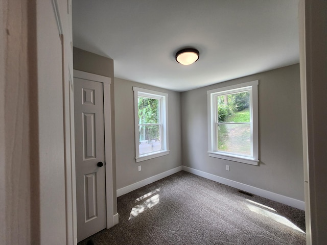 empty room featuring dark carpet