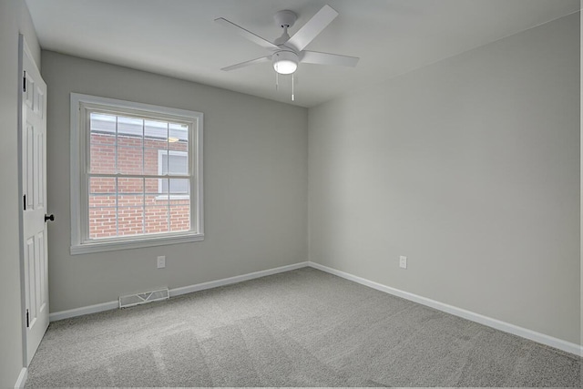 spare room with ceiling fan and light carpet