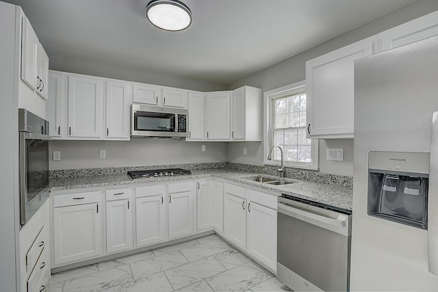 kitchen featuring light stone counters, sink, white cabinetry, and appliances with stainless steel finishes