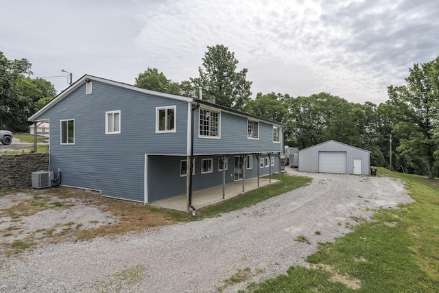 exterior space with a garage, an outbuilding, and central AC