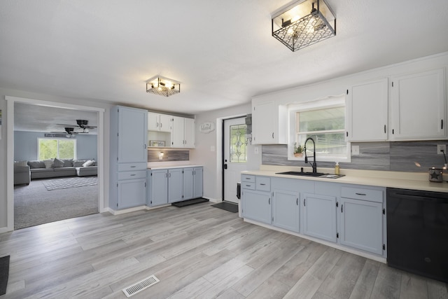 kitchen featuring light carpet, decorative backsplash, dishwasher, white cabinets, and sink