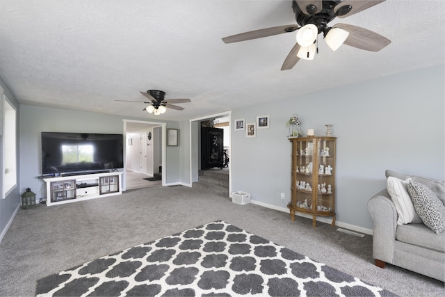 unfurnished living room with a textured ceiling, ceiling fan, and carpet floors