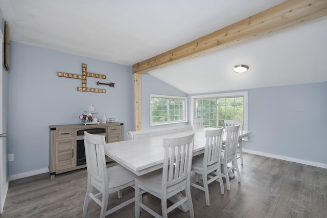 dining area featuring dark wood-type flooring and vaulted ceiling with beams