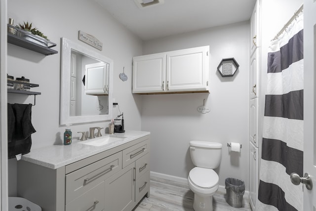 bathroom featuring wood-type flooring, toilet, and vanity