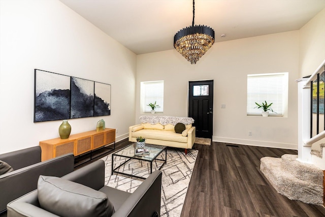 living room with an inviting chandelier and dark hardwood / wood-style flooring