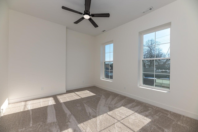 unfurnished room with ceiling fan and carpet