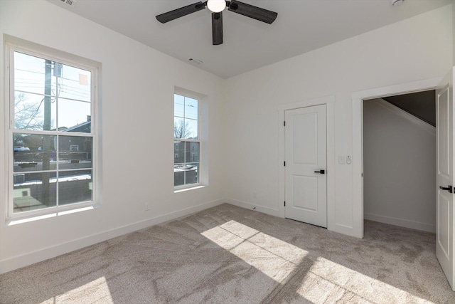 unfurnished bedroom with ceiling fan and light colored carpet