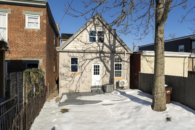 snow covered back of property featuring cooling unit