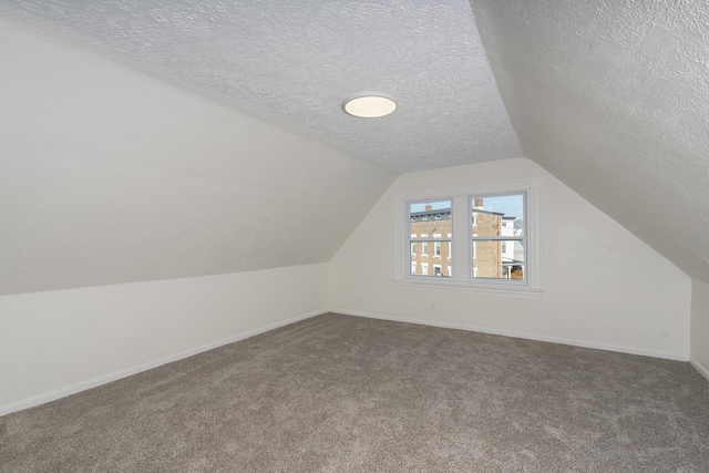 bonus room featuring carpet, a textured ceiling, and lofted ceiling